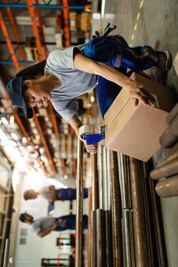 Proiecte 5 female warehouse worker taping cardboard box with tape dispenser before shipment 1 scaled e1747414553782 Proiecte