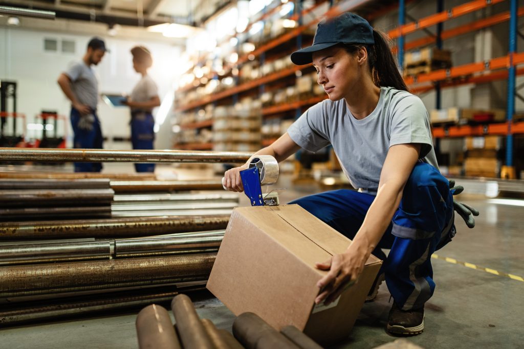 Proiecte 9 female warehouse worker taping cardboard box with tape dispenser before shipment Proiecte